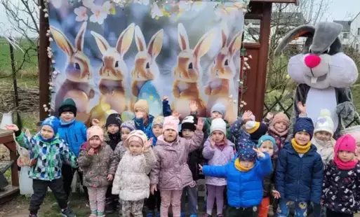 Dzieci na wycieczce na tle obrazków z zajączkami 